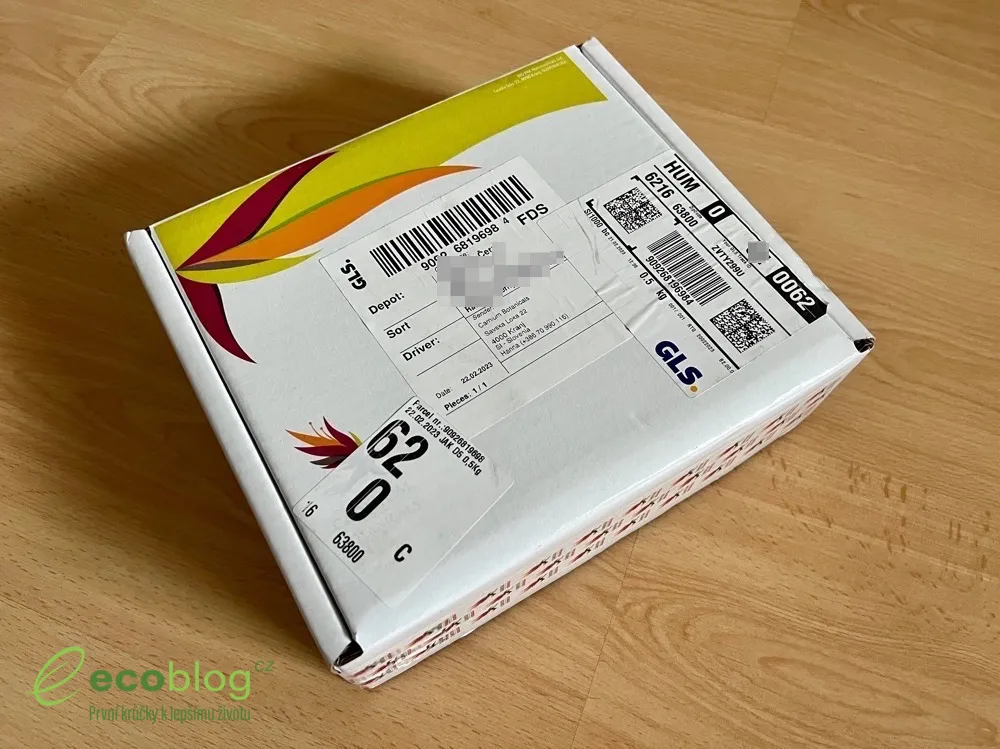 Doručená krabica Carnium Botanicals s logom na drevenej podlahe