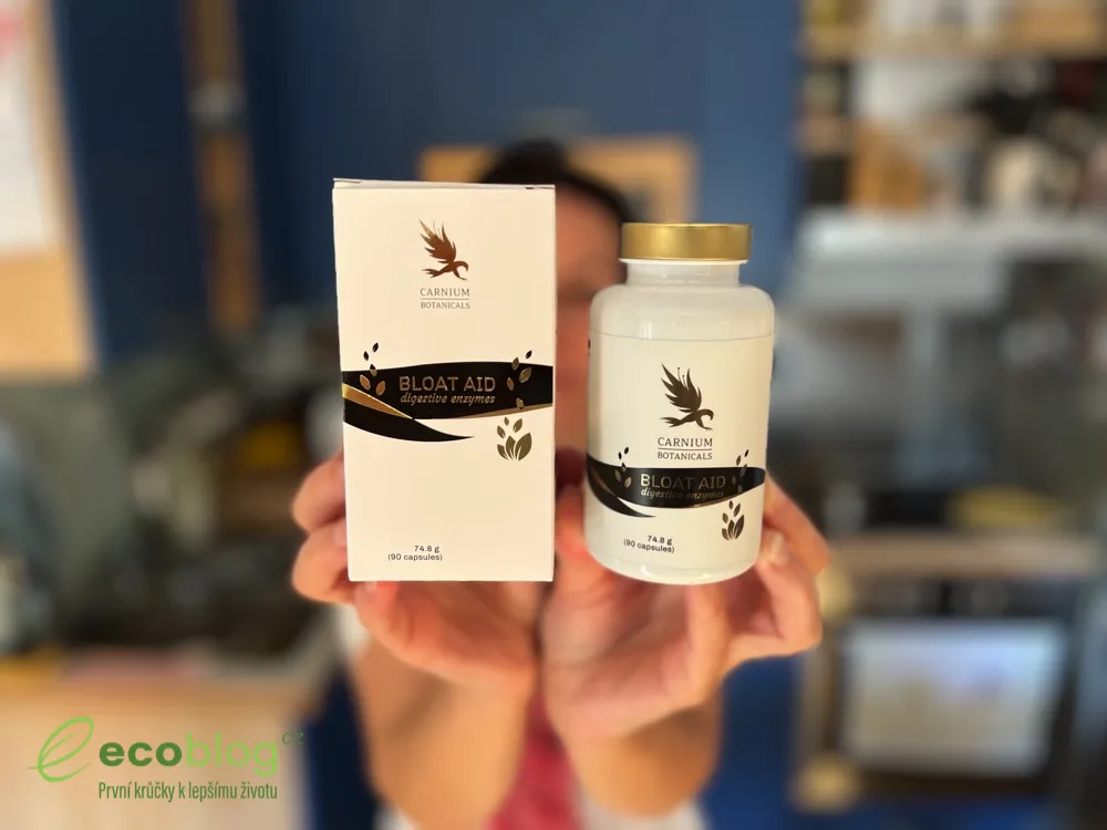 Ruky držia krabičku a dózu Bloat Aid od Carnium Botanicals